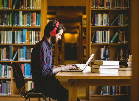 在线博彩 student working on homework in the library.